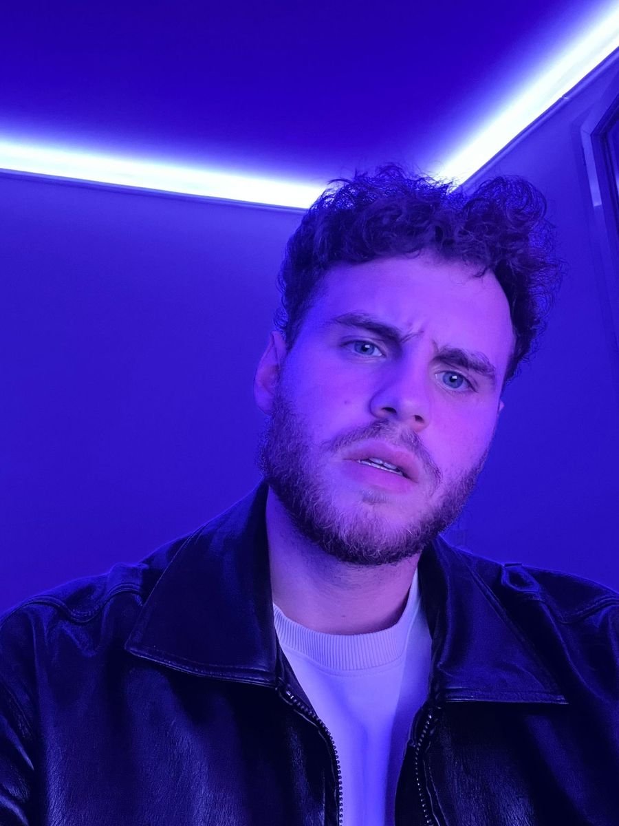 Arthur Allard, DJ et producteur de musique électronique, sous un néon bleu